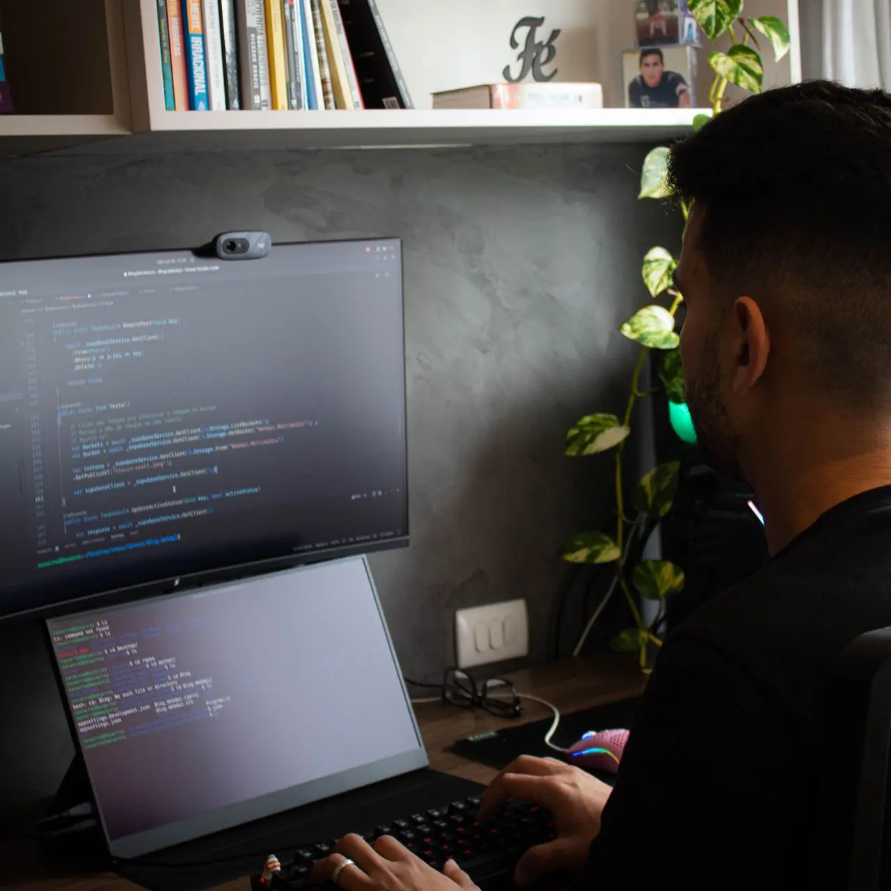 Entwickler programmiert an Bildschirm und Laptop