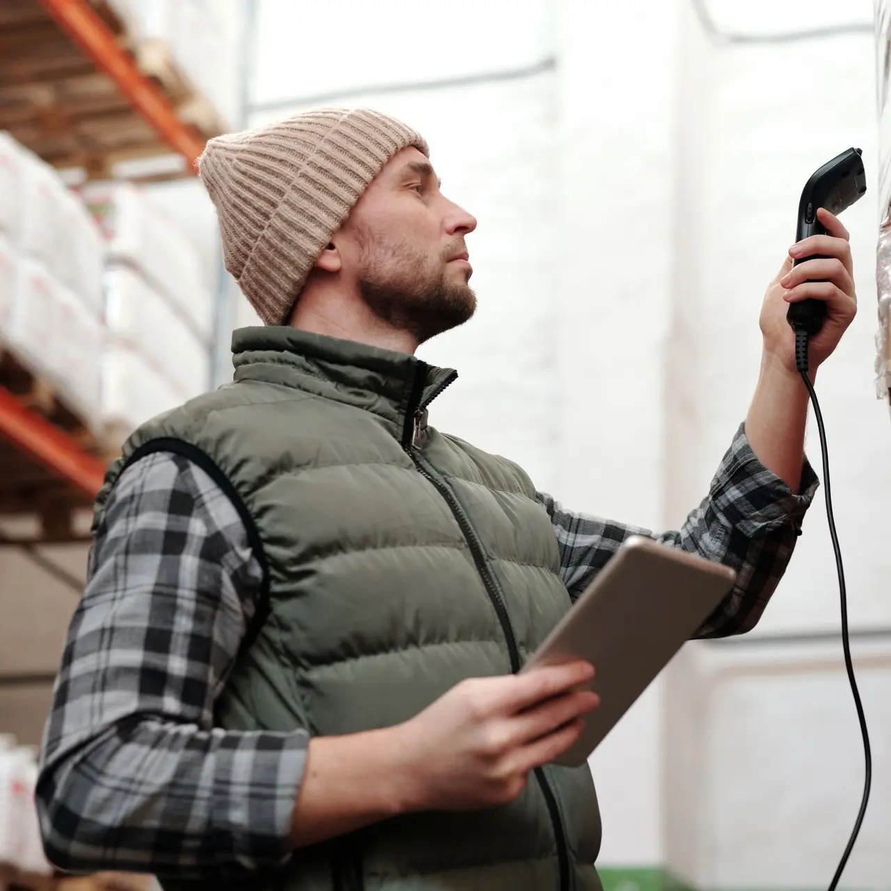 Lagermitarbeiter mit Tablet und Handscanner zwischen Regalen