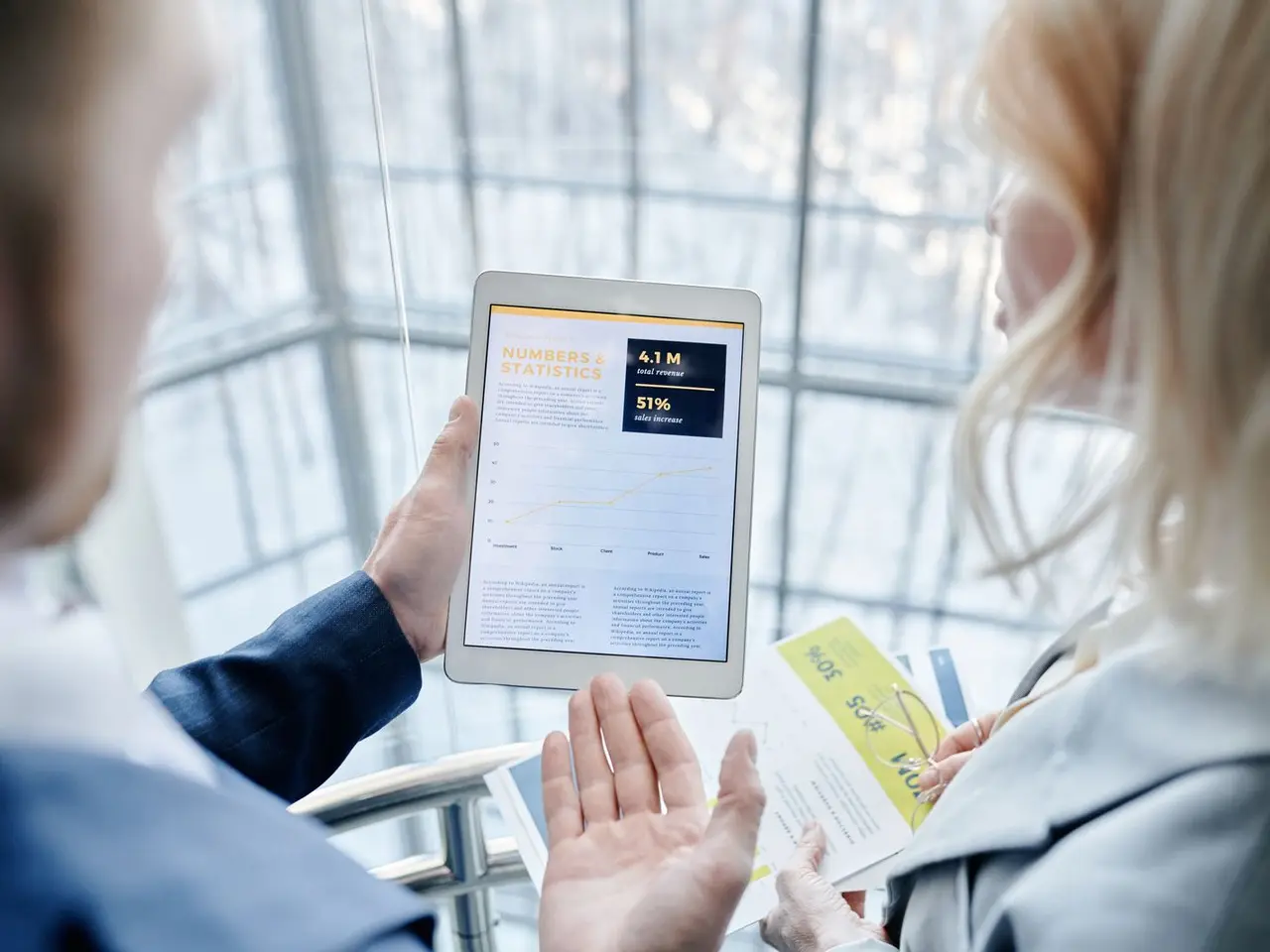 Zwei Personen im Büro schauen gemeinsam auf eine Geschäftsapp auf dem Tablet